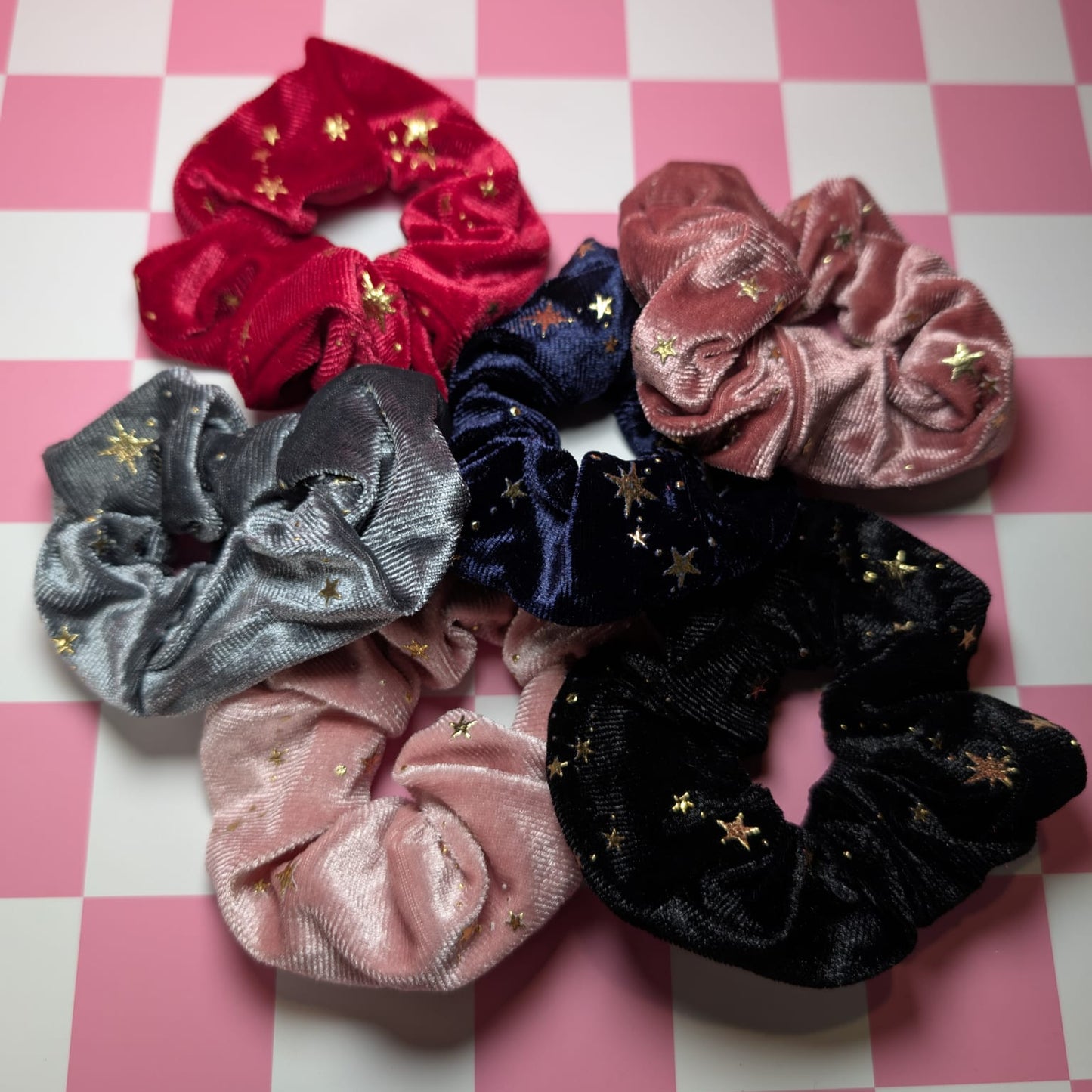 Set of colorful scrunchies with star patterns on a pink and white checkered background