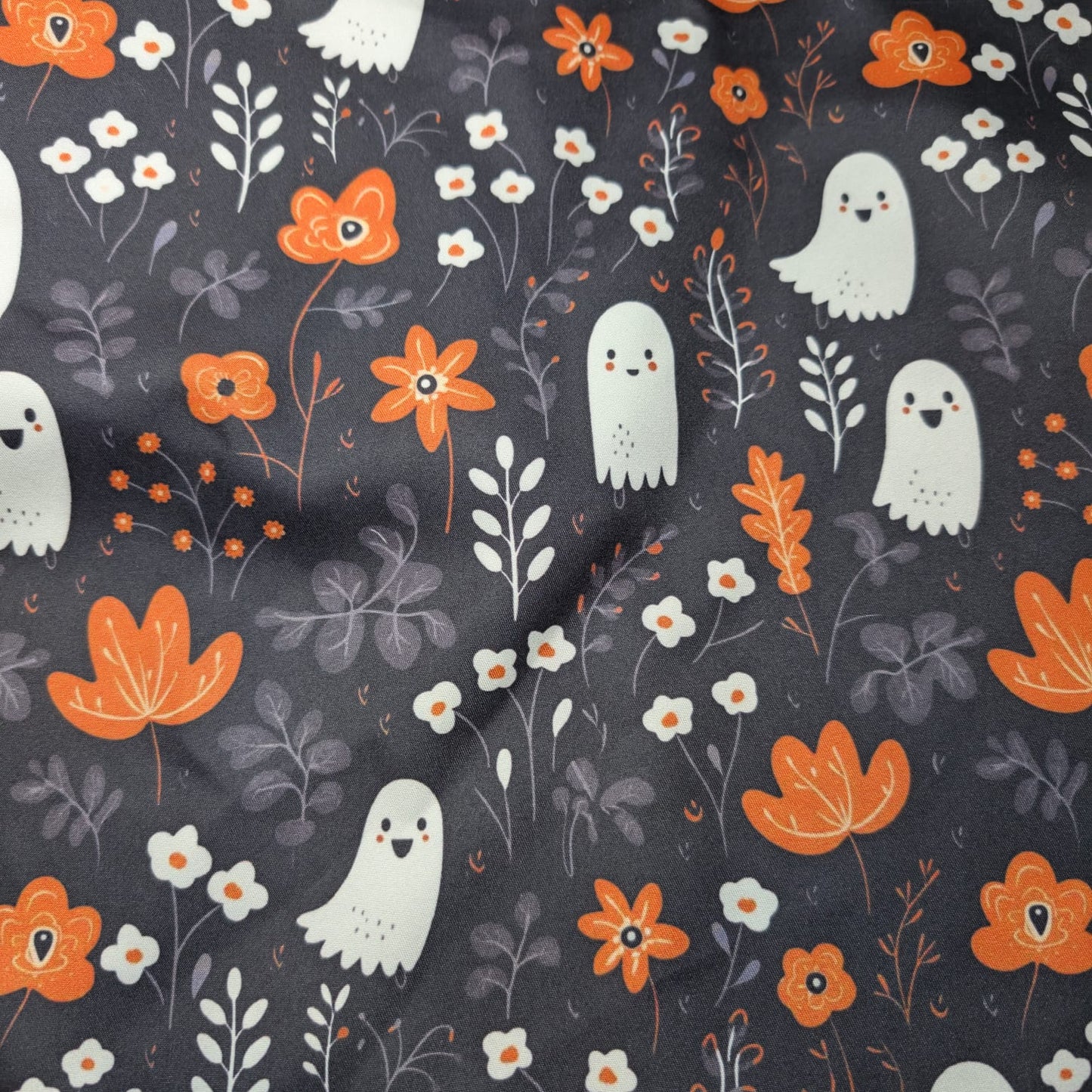 Fabric with ghost and floral pattern on a dark background