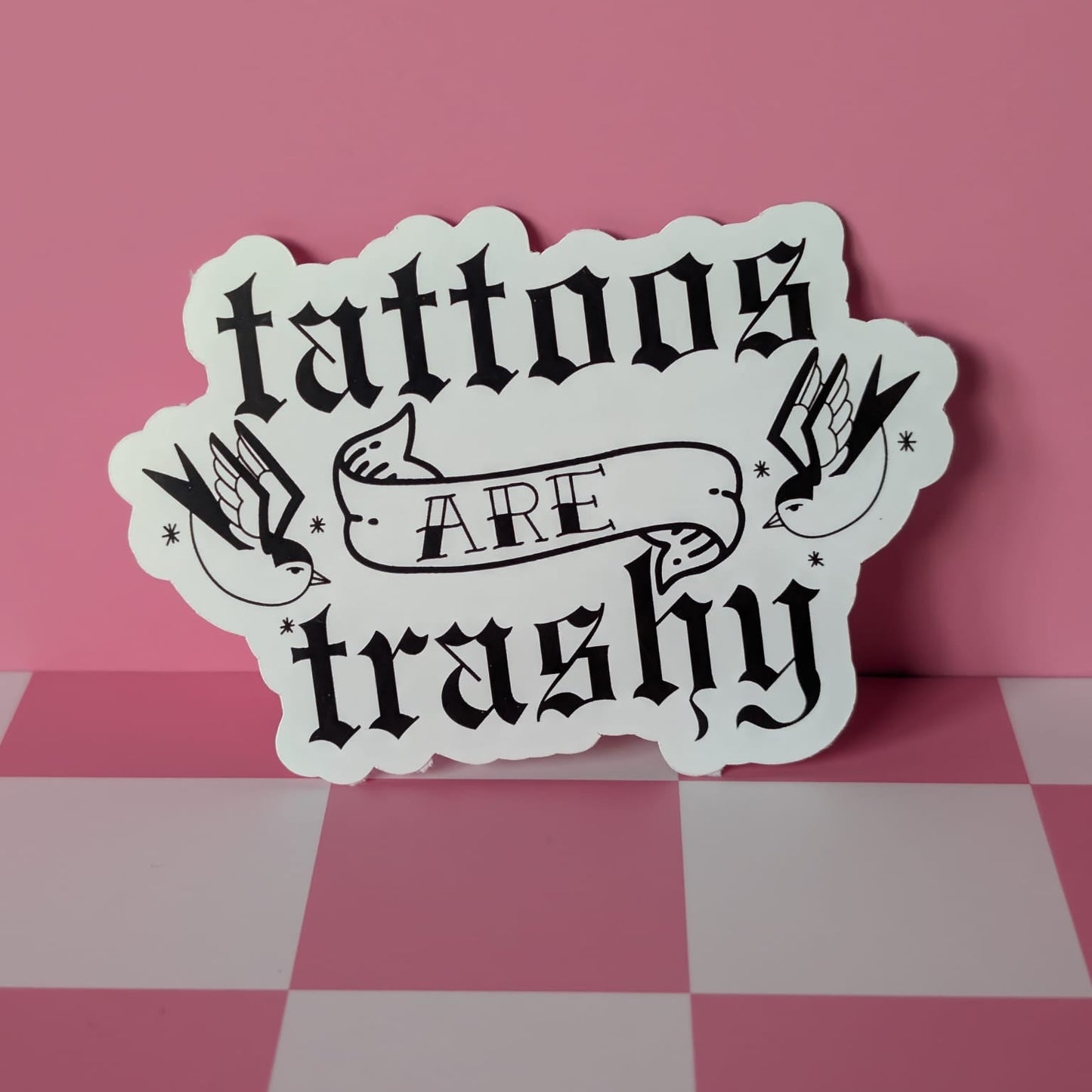 Sticker with 'tattoos are trashy' text on a pink and white checkered background
