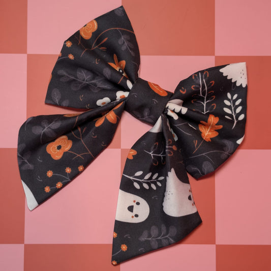 Decorative bow with Halloween-themed design on a pink checkered background