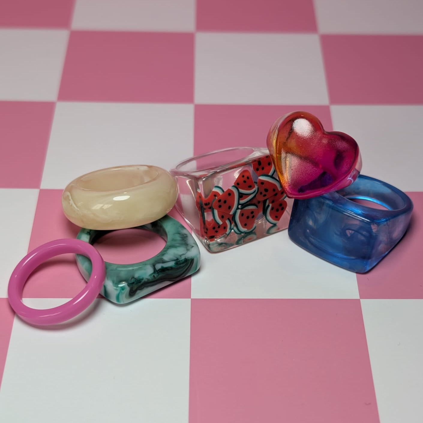 Set of colorful rings on a pink and white checkered background