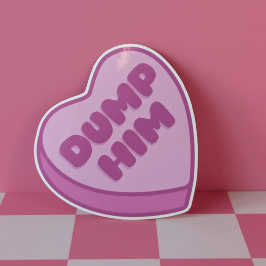 Heart-shaped sign with 'Dump Him' text on a pink and gray checkered floor.
