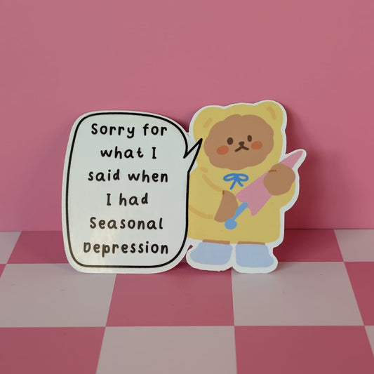 Sticker of a bear holding a pink ribbon with text on a pink and white checkered background