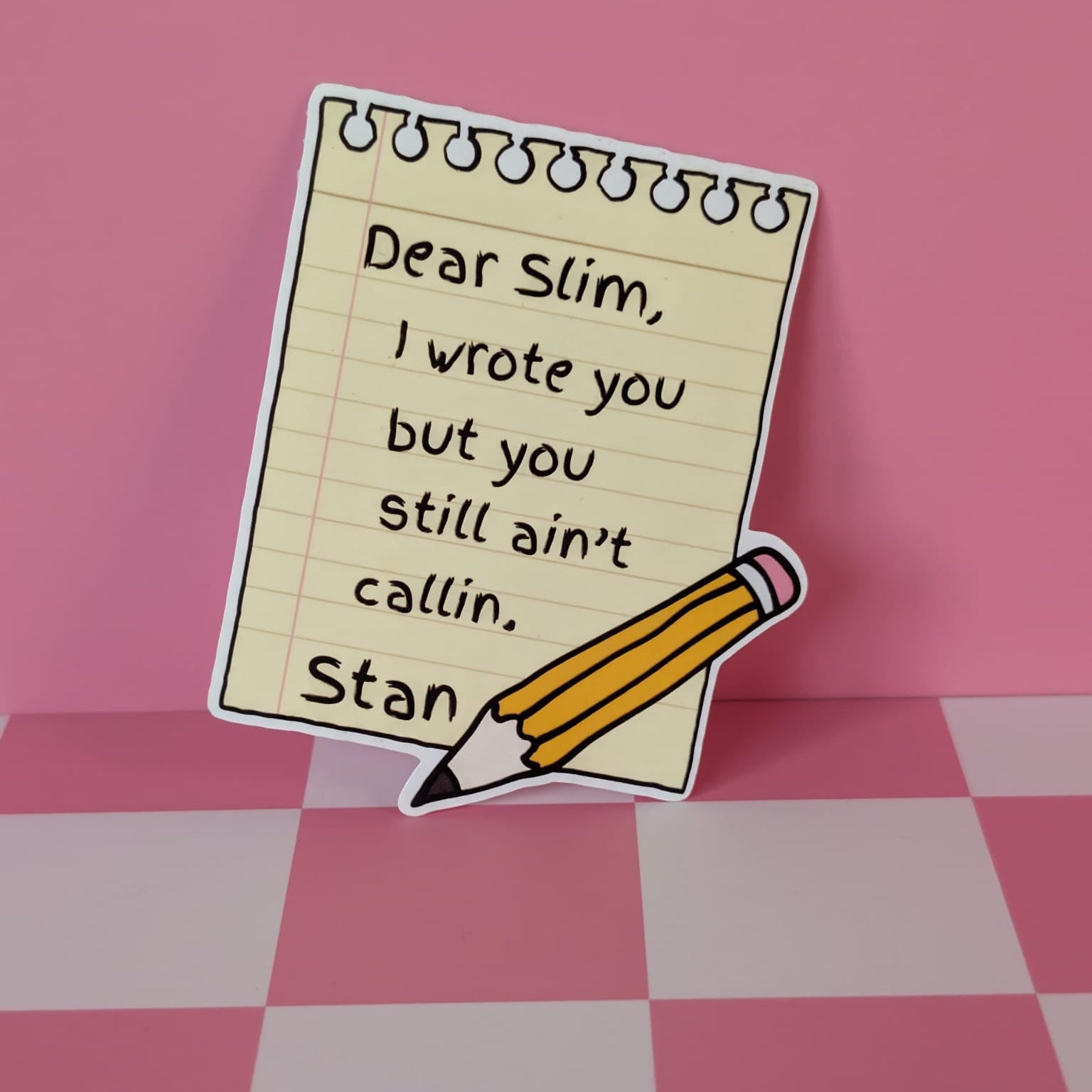 Note with text 'Dear Slim, I wrote you but you still ain't callin. Stan' on a pink checkered background