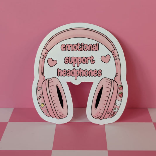 Pink headphones with 'emotional support headphones' text on a pink checkered background