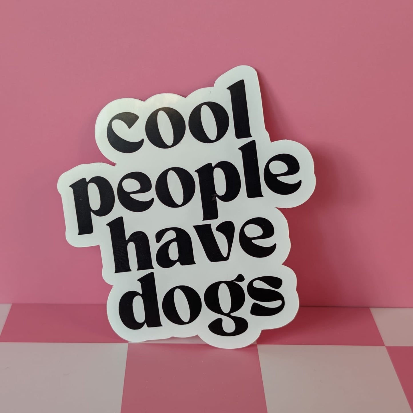 Sticker with 'cool people have dogs' text on a pink background