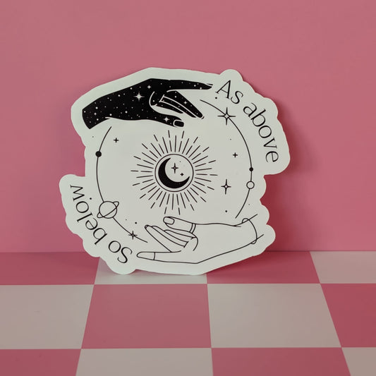 Decorative sticker with hands and celestial design on a pink checkered background